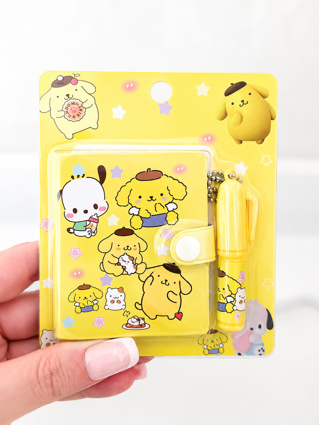 Mini carnet kawaii Sanrio et stylo tenus en main pour montrer la taille – Mimisu
