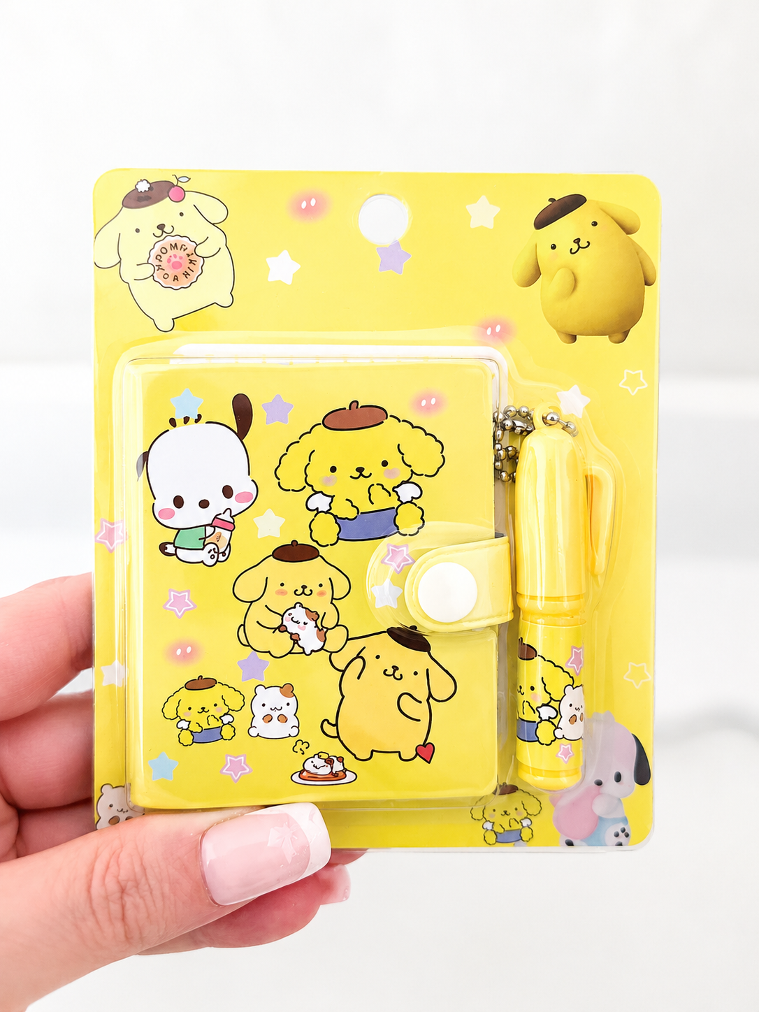 Mini carnet kawaii Sanrio et stylo tenus en main pour montrer la taille – Mimisu
